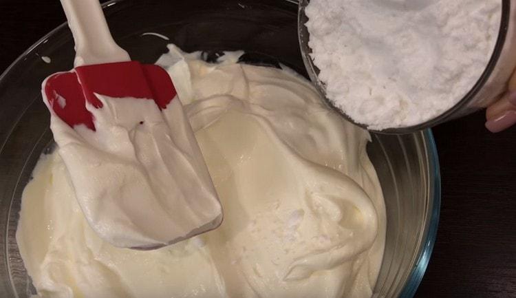 Per preparare la crema, mescolare la panna acida con lo zucchero a velo.