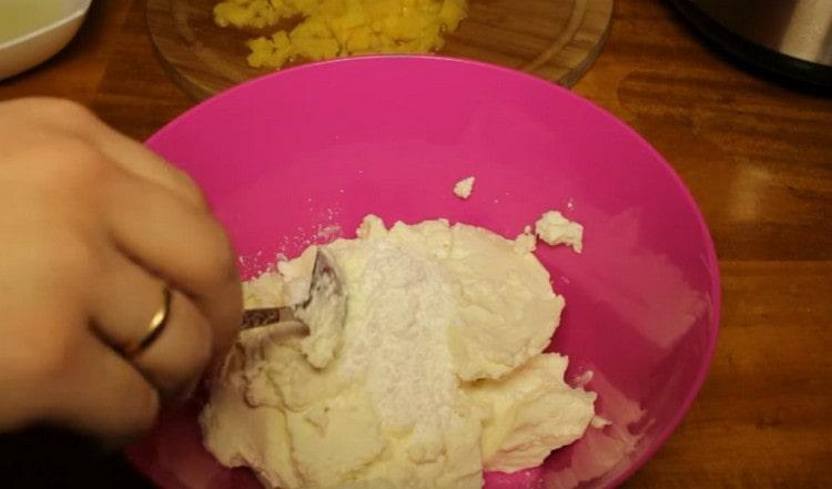 Για να προετοιμάσετε την κρέμα, ανακατέψτε το τυρόπηγμα με σκόνη ζάχαρης.