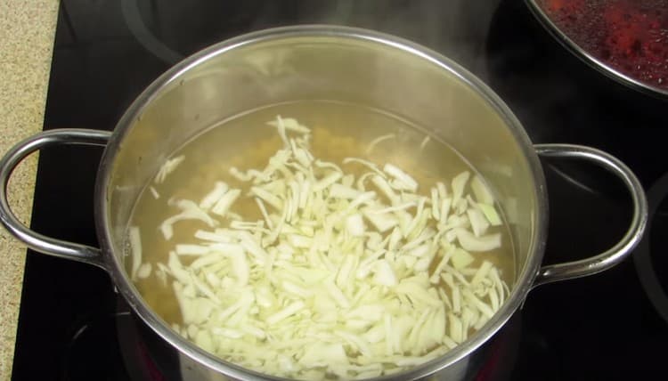 Βάζουμε λάχανο σε μια κατσαρόλα με σχεδόν έτοιμα φασόλια.