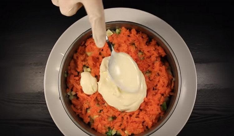 Na okurku položte vrstvu strouhané mrkve a namažte ji majonézou.
