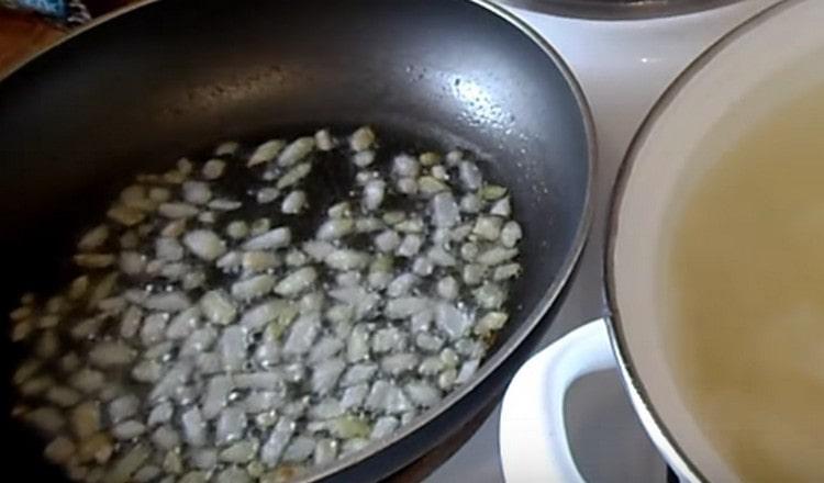 في مقلاة مع الزيت النباتي ، تقلى البصل المفروم.