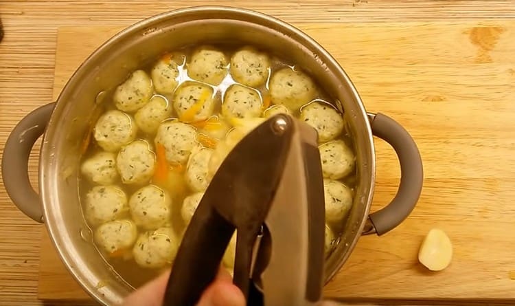 Drücken Sie den Knoblauch durch eine Presse in die Suppe.