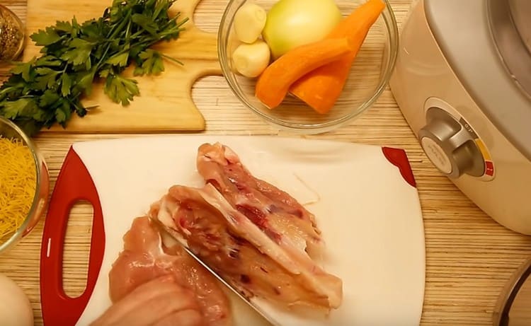 Πάρτε το στήθος κοτόπουλου και διαχωρίστε το κρέας από τα οστά.