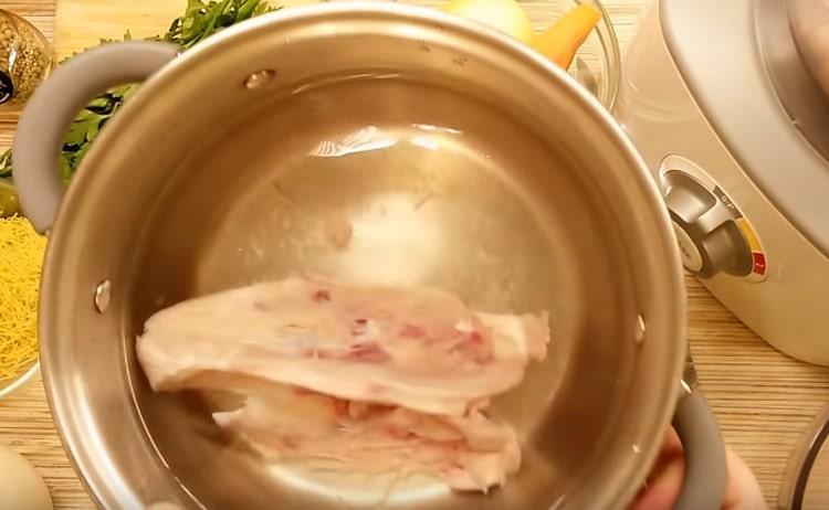 Изсипете кокошката пилешка гърда в тенджера с вода и поставете да заври.