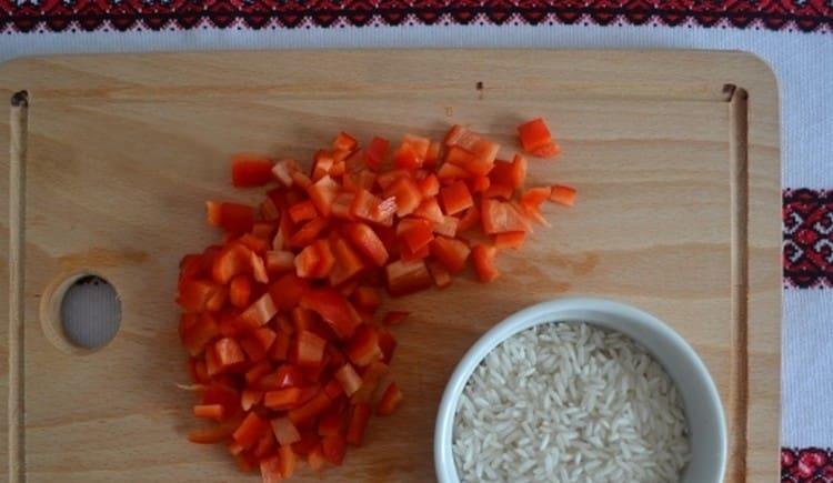 Wir waschen den Reis und schneiden die Paprika in Stücke.