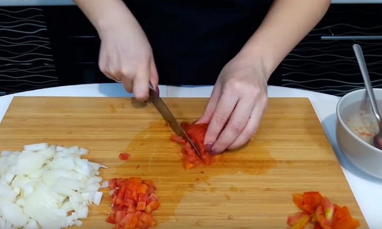Die Tomate in kleine Stücke schneiden.