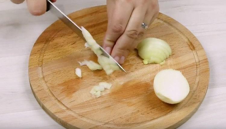 Macinare la cipolla sul tagliere.