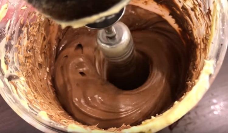Wir unterbrechen die Butter mit Schokolade, bis sie glatt ist.