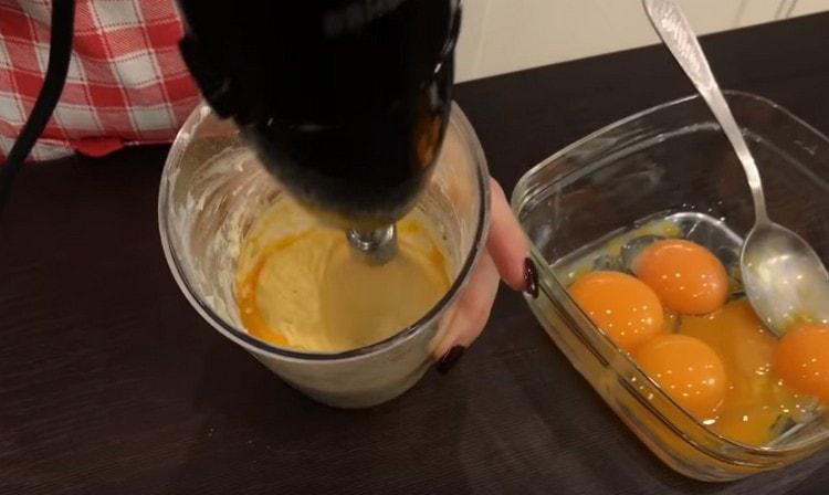 Führen Sie nacheinander das Eigelb in die Butter ein und peitschen Sie die Masse.