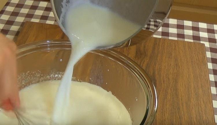 A forró tejet fokozatosan vezetik be a tojásmasszába.