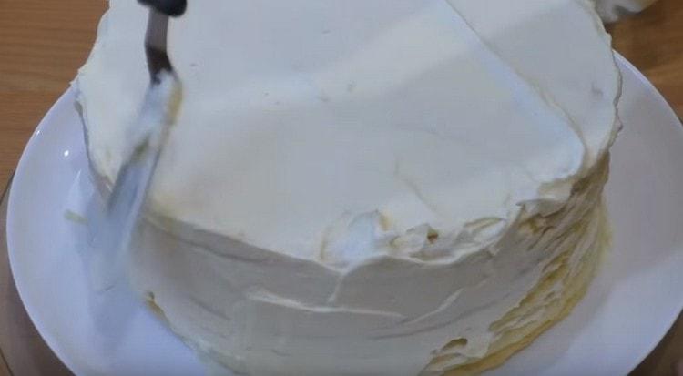 معطف الجزء العلوي والجانبين من الكعكة مع كريم.