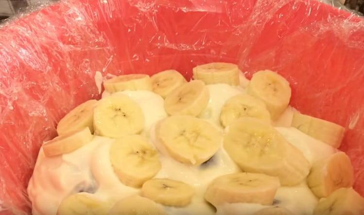 Отгоре върху крема подредете слой банани.