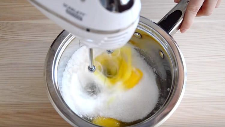 Pirmiausia kiaušinius išplakite su cukrumi.