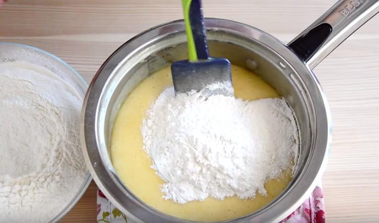 Fügen Sie das Mehl in Portionen hinzu und kneten Sie den Teig.