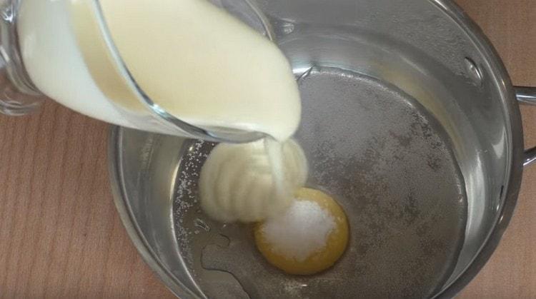 أضف سكر الفانيليا والحليب المكثف والماء إلى صفار البيض.
