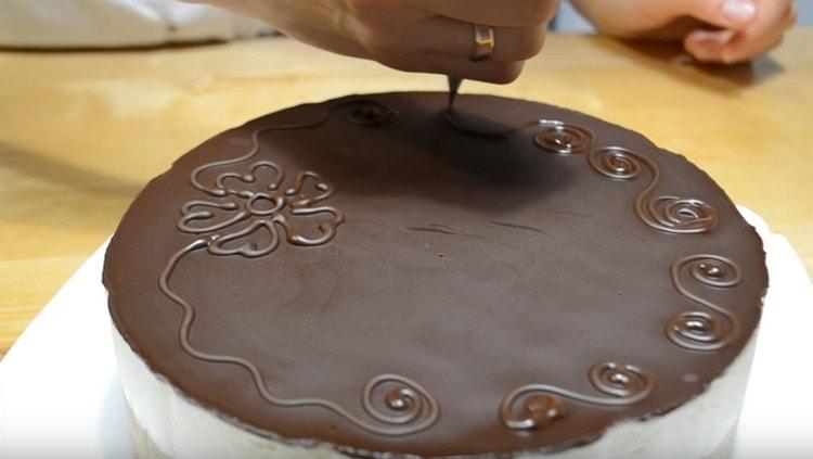 Aus den Resten der Glasur können Sie, wenn sie ein wenig aushärtet, Dekorationen für den Kuchen anfertigen.