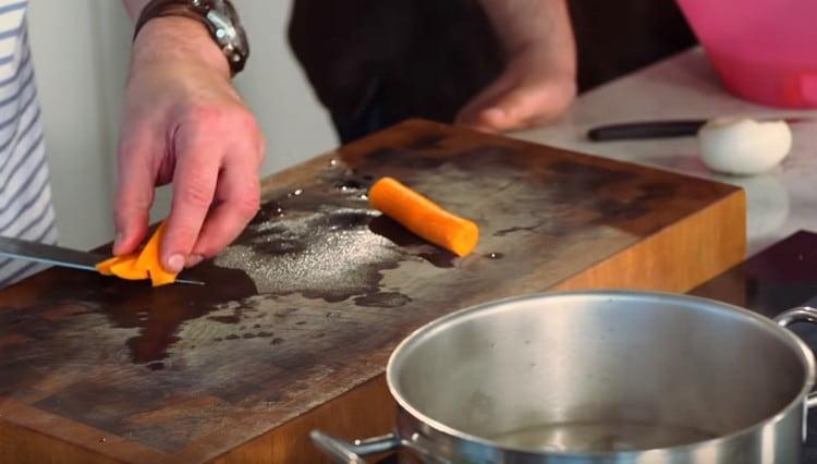 Нарежете морковите на големи парчета и изпратете в бульона.