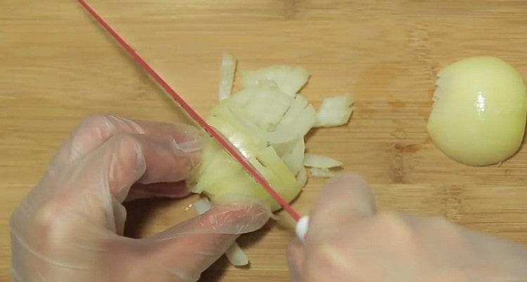 Tritare le cipolle e l'aglio.