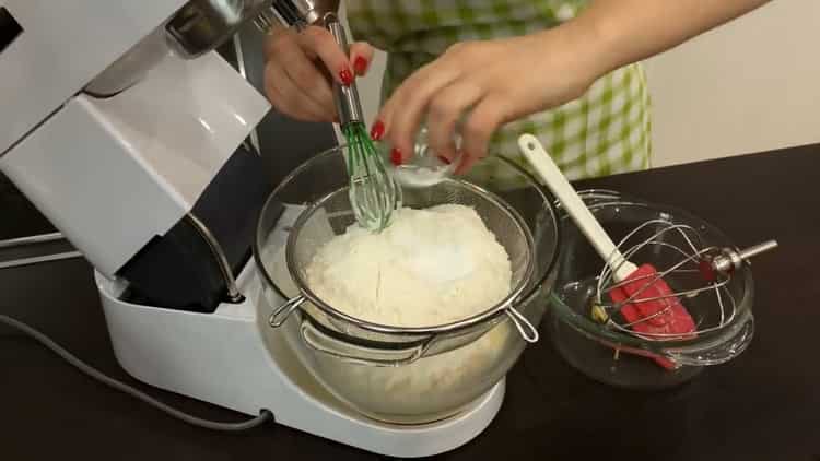 Setacciare la farina per fare una torta di tartaruga con panna acida