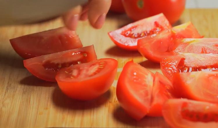 Per cucinare uno stufato di verdure con carne, tagliare i pomodori