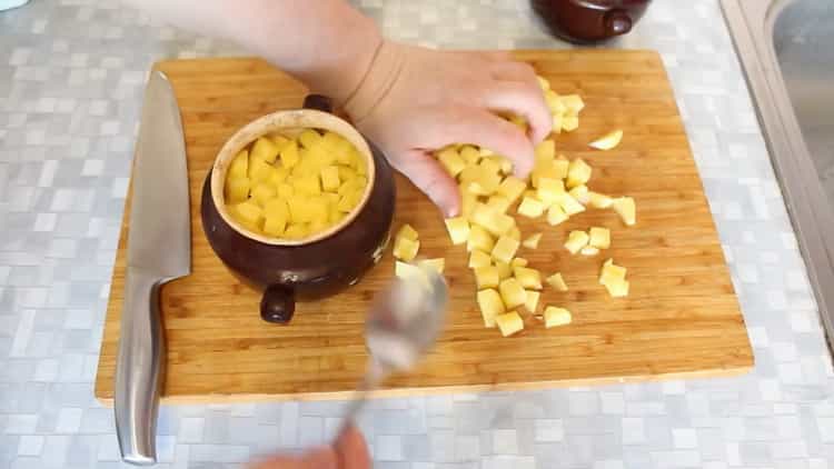 Um Rindfleisch in Töpfen mit Kartoffeln im Ofen zu kochen, legen Sie die Kartoffeln