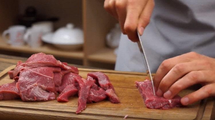 Нарежете говеждото месо на тънки, дълги филийки.
