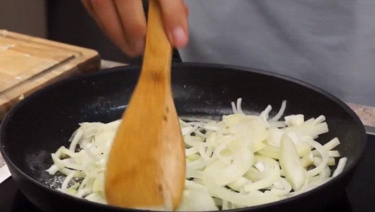 Ξεχωριστά, τηγανίζουμε τα κρεμμύδια σε μια κατσαρόλα με βούτυρο.