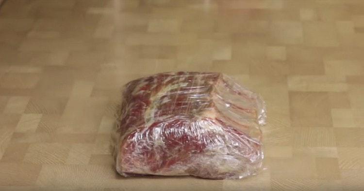 Avvolgi la carne in pellicola trasparente e inviala in salamoia in frigorifero per un giorno.