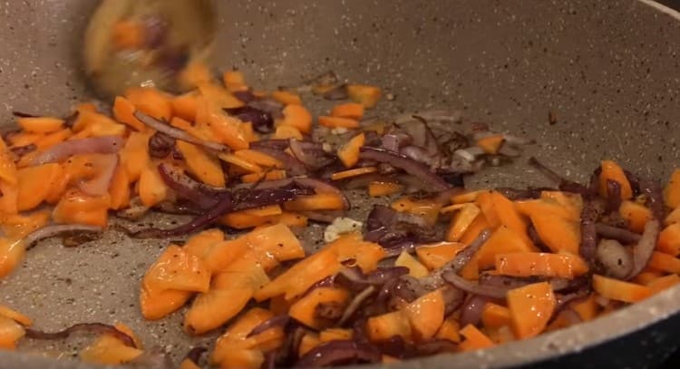 Dann Karotten in die Zwiebel geben und noch ein paar Minuten braten.