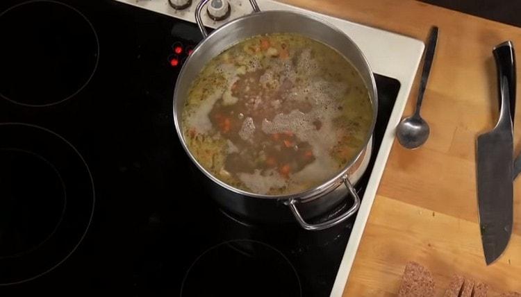 Fügen Sie Buchweizen- und Hühnerherzen zu einer fast fertigen Suppe hinzu.