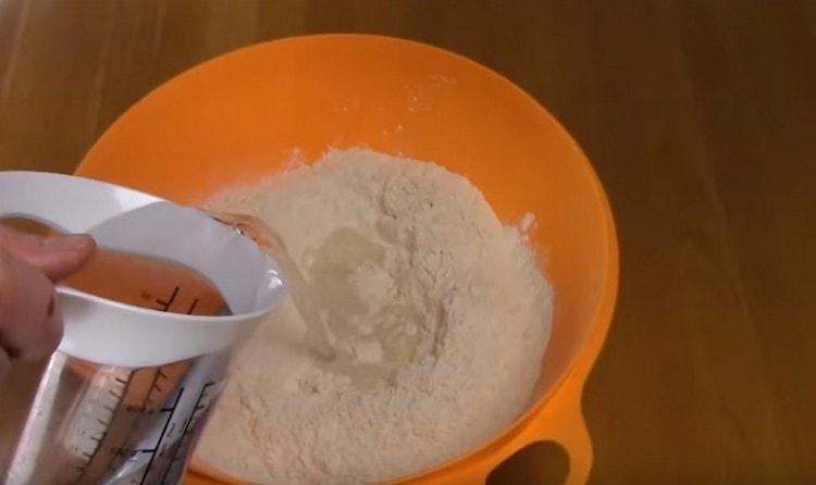 Добавете вода към брашното и омесете тестото.
