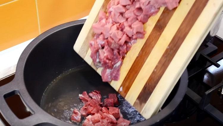 Quando l'aglio è dorato, rimuovilo e metti la carne nel calderone.