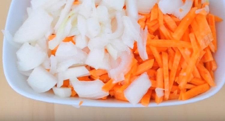 Wir schneiden Zwiebeln in halbe Ringe und Karotten in Streifen.