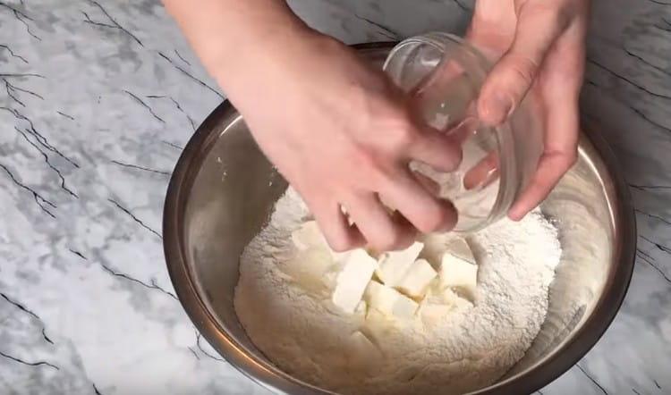 V suchých surovinách rozprostřete máslo nakrájené na kousky.