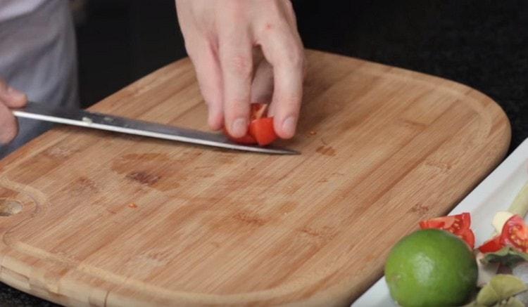 Vyšniniai pomidorai supjaustomi į keletą dalių.