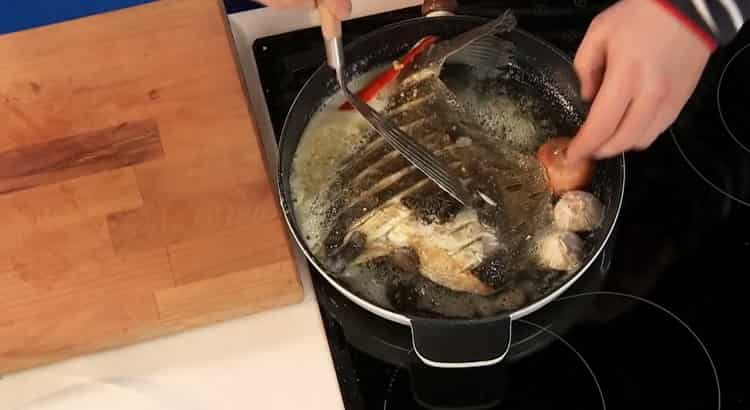 Um gebratene Flunder in einer Pfanne zu kochen, den Fisch in Öl geben