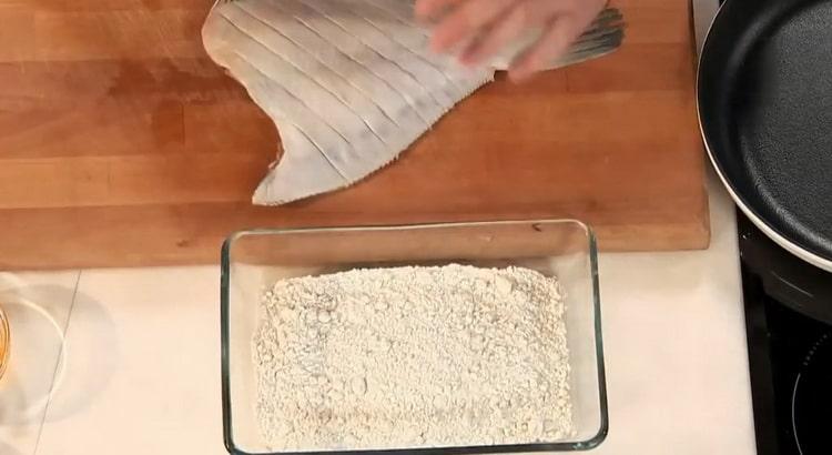 Um gebratene Flunder in einer Pfanne zu kochen, geben Sie den Fisch in Mehl