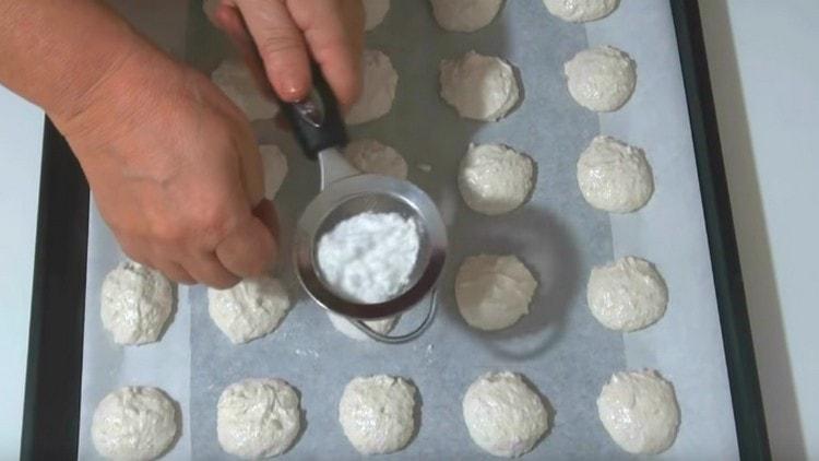 Bestrooi elk koekje met poedersuiker door een zeef.