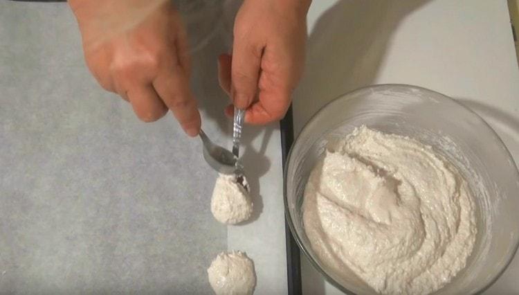 Levitä pergamentilla peitetylle leivinlevylle manteliproteiinimassa lusikoilla.