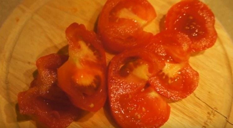 Die Tomate in dünne Scheiben schneiden.
