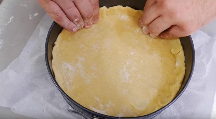 A tésztát formába tesszük, formáljuk az oldalakat.