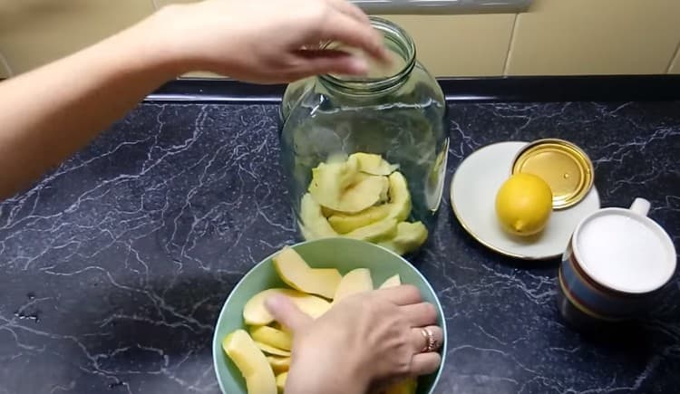 Mettiamo le fette di mela cotogna in un barattolo sterilizzato.