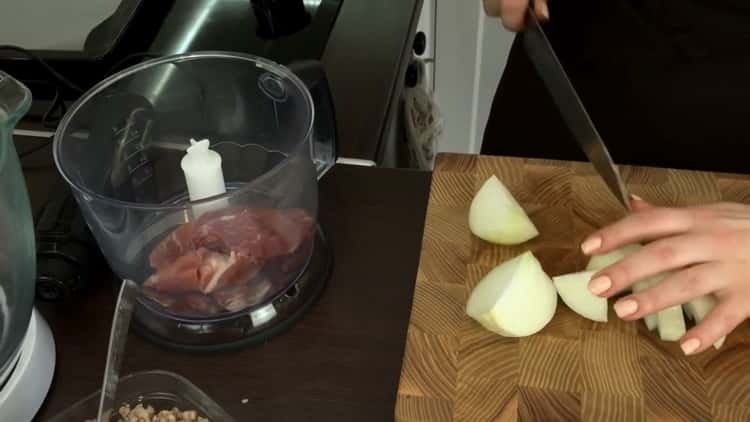Für die Zubereitung von Buchweizenkoteletts Zwiebel und Fleisch hacken