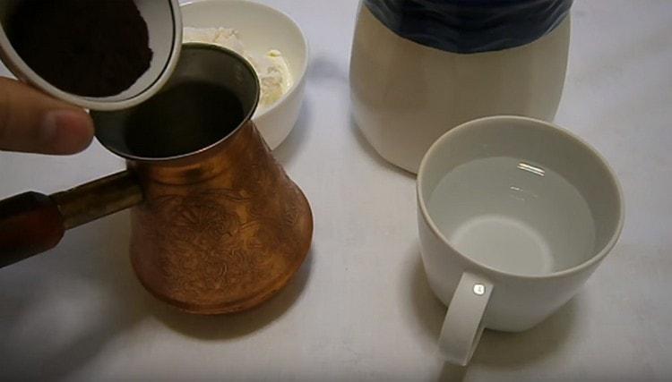 Gießen Sie natürlichen gemahlenen Kaffee in den Türken.