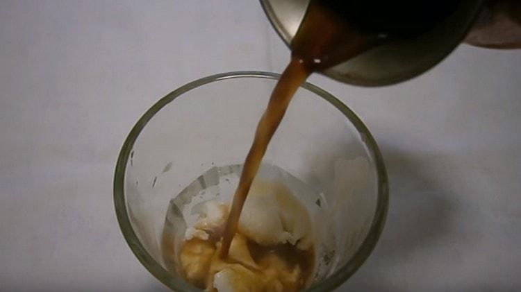 Gießen Sie vorsichtig Kaffee in ein Eisglas.