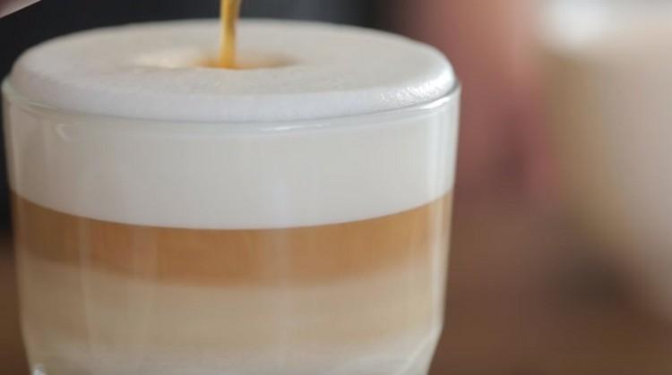 Geben Sie den Kaffee vorsichtig in einen dünnen Strahl in die geschlagene Milch.