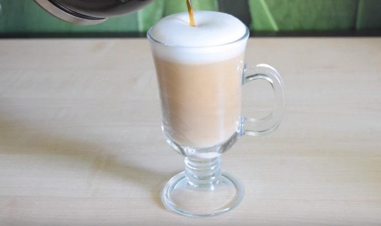 Nach der Schaumbildung einen dünnen Strahl in den Milchkaffeeschaum geben.