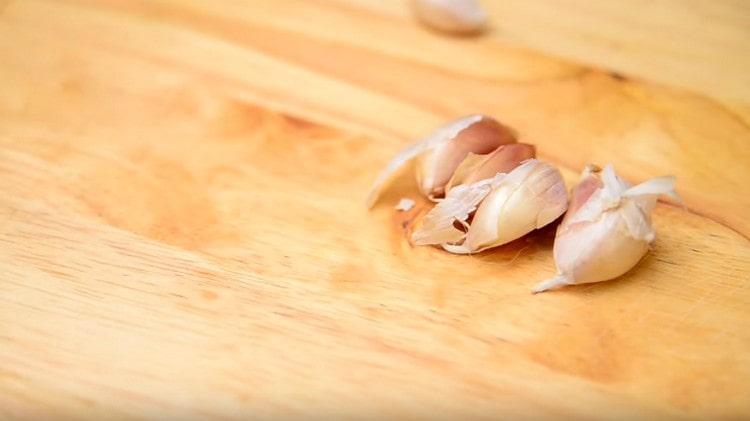 Schiacciamo l'aglio con il lato piatto del coltello e la buccia, il taglio non è noioso.