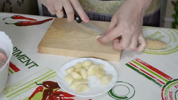Για να μαγειρέψετε τα πόδια κοτόπουλου στο φούρνο, κόψτε το σκόρδο