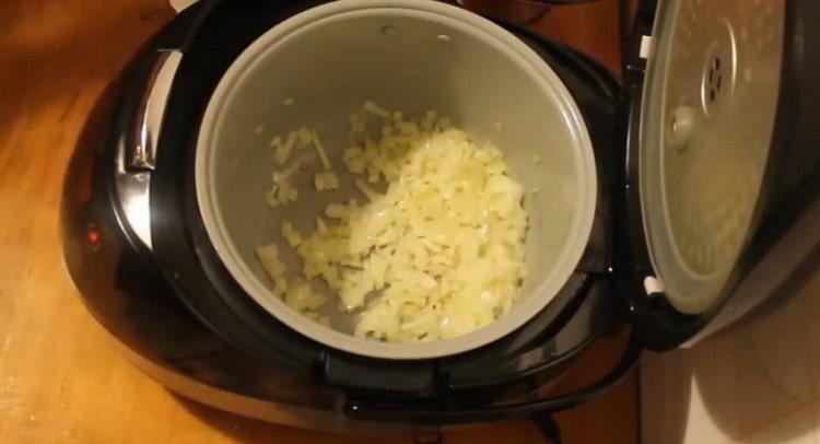 Wir verteilen die gehackten Zwiebeln in einem Slow Cooker.